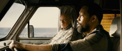 a man driving a truck next to another man