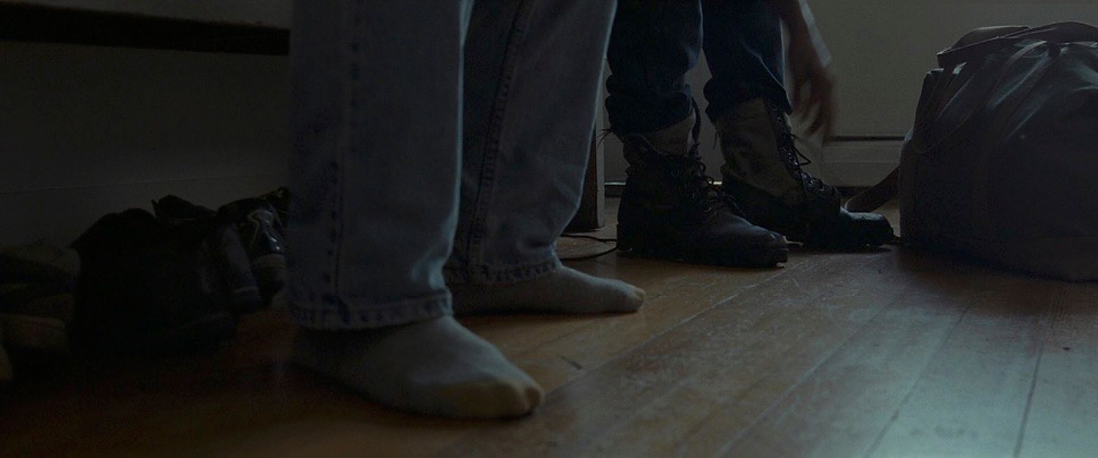 two people standing next to each other on a wooden floor