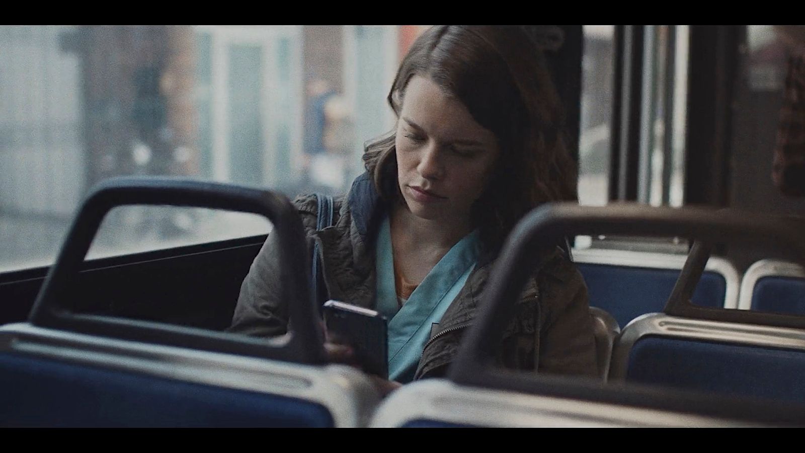 a woman sitting on a bus looking at her phone