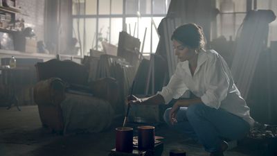 a woman kneeling down in a room filled with furniture