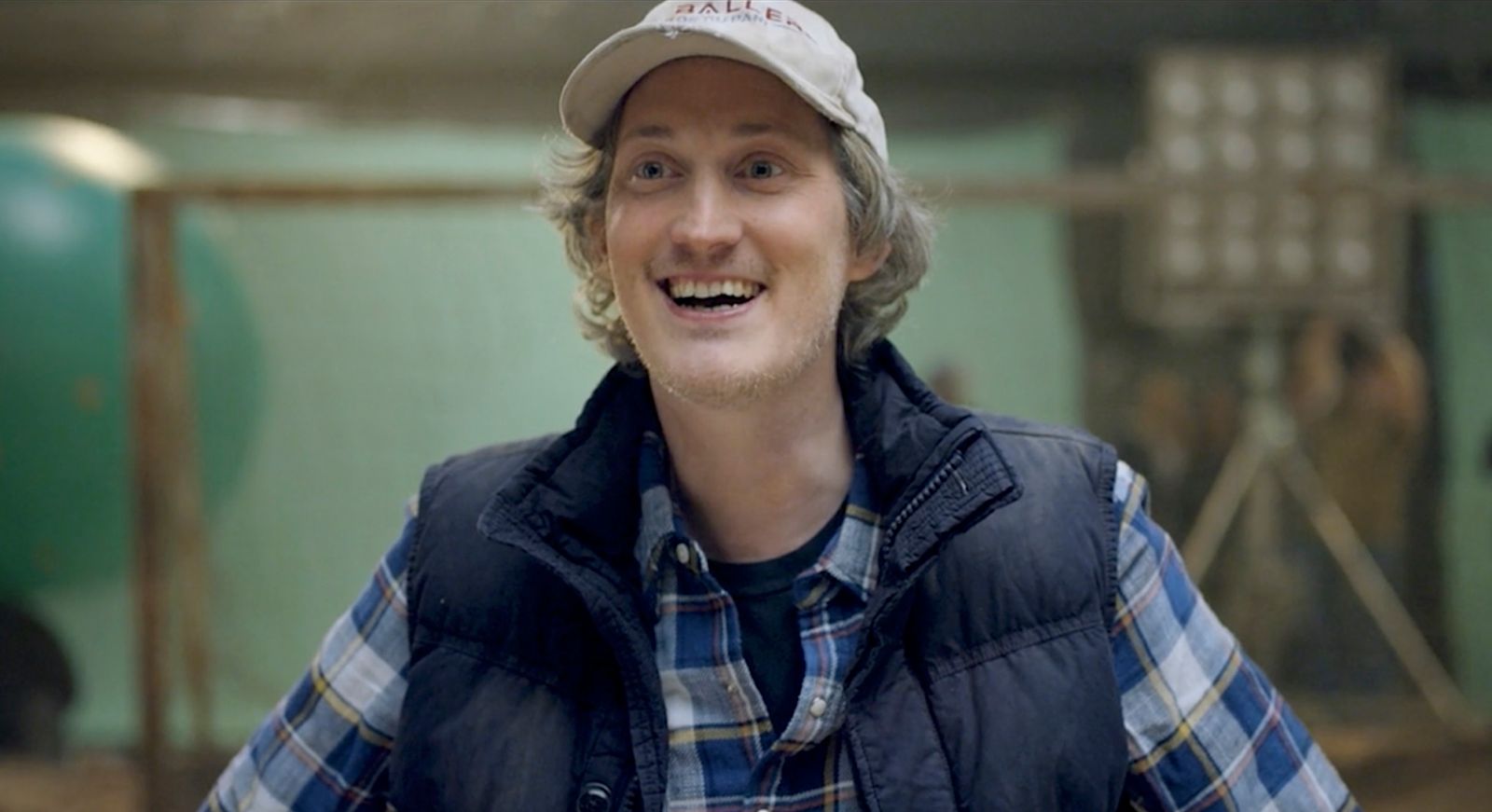 a man in a plaid shirt and a baseball cap