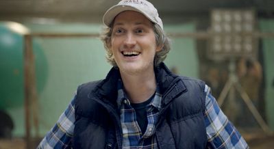 a man in a plaid shirt and a baseball cap