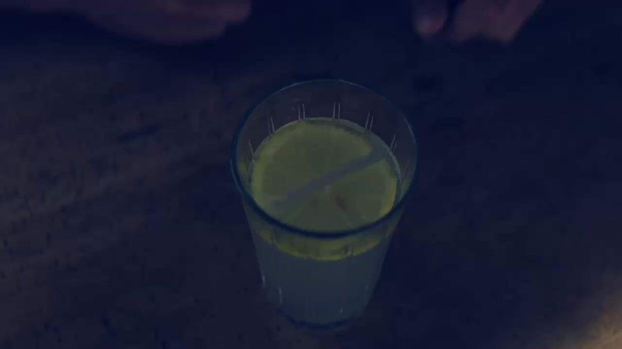 a glass of green liquid sitting on a table