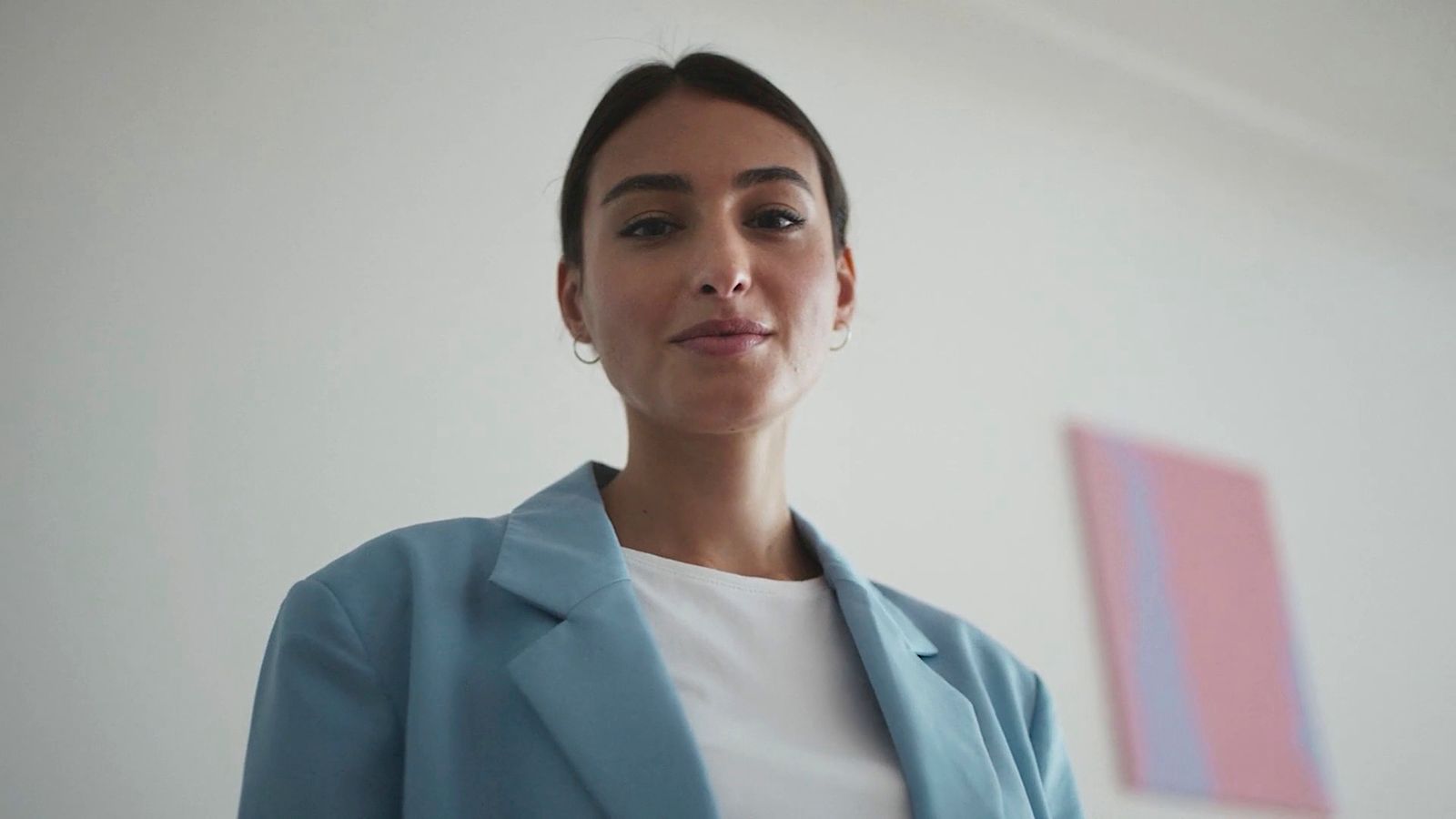 a woman standing in front of a white wall