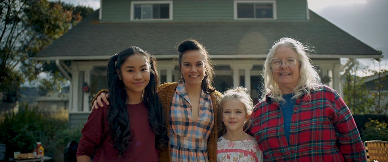 a group of women standing in front of a house