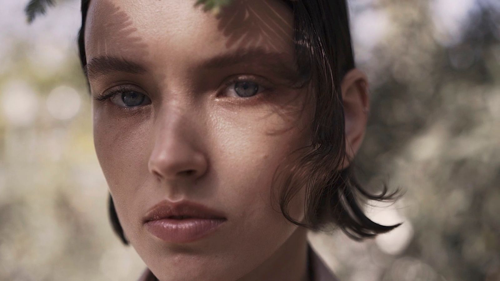 a close up of a person with a tree in the background