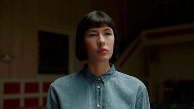 a woman standing in a room with a blue shirt on