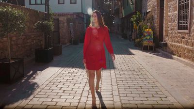 a woman in a red dress walking down a street