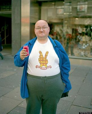 a man standing on a sidewalk holding a cell phone