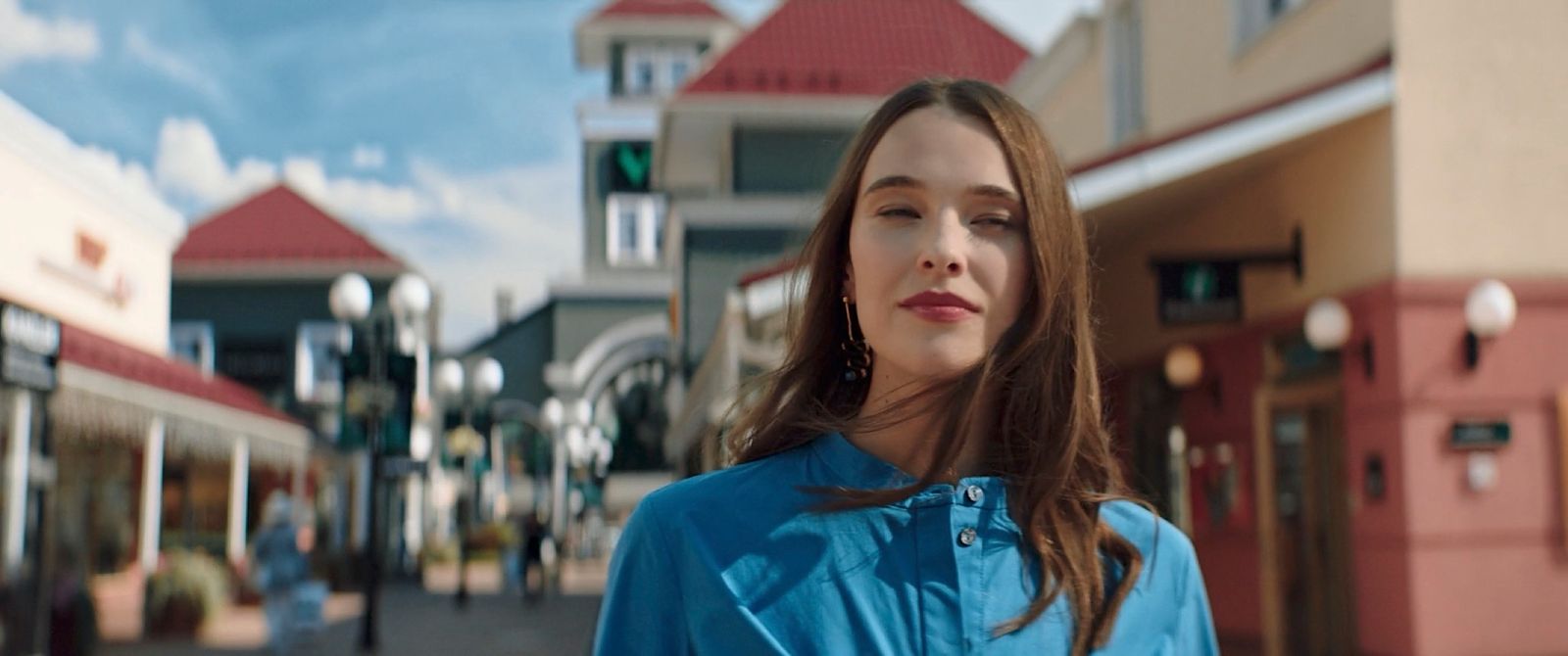 a woman standing in front of a building on a street