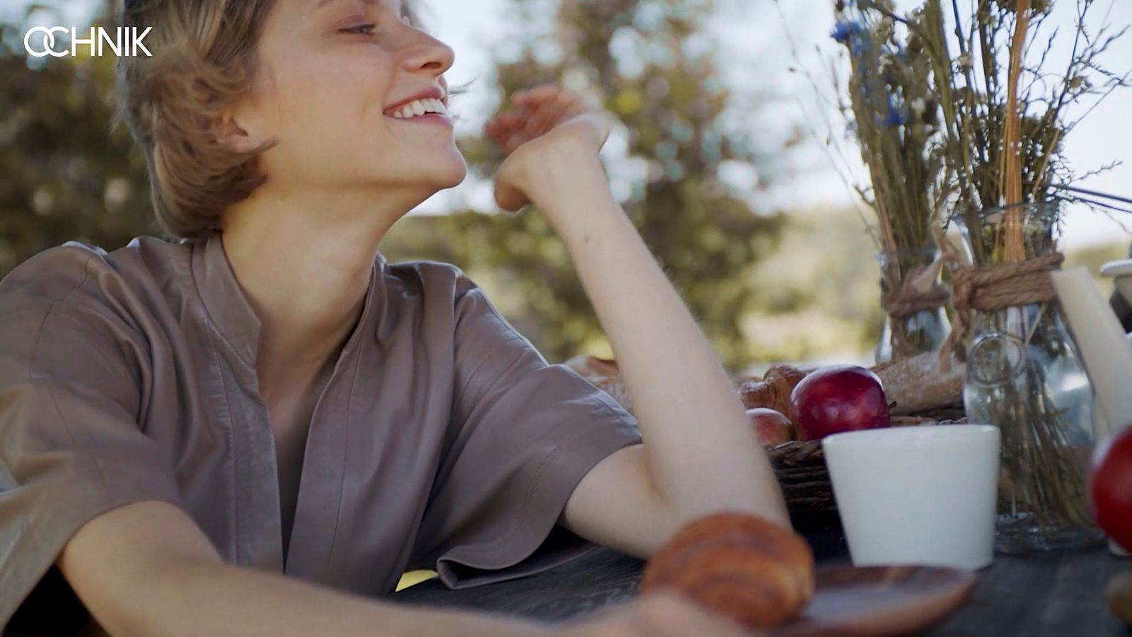 a woman sitting at a table with a plate of food