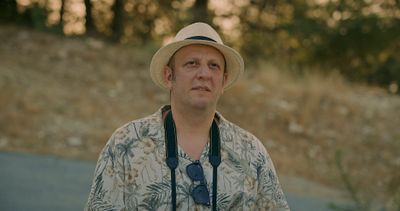 a man wearing a hat and a camera around his neck