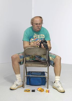 a man sitting in a chair with a camera