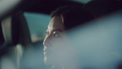 a woman sitting in a car looking out the window