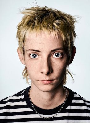 a young man with blonde hair wearing a striped shirt