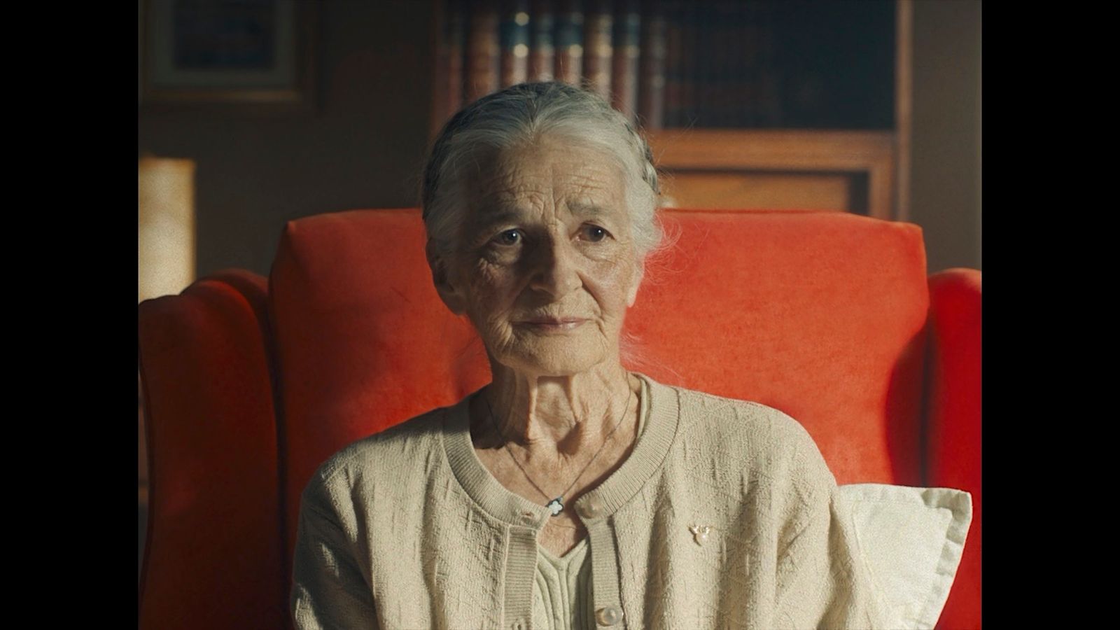 an old woman sitting in a red chair