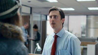 a man in a dress shirt and tie talking to a woman