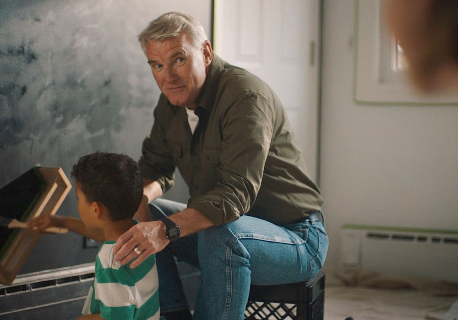 a man sitting next to a little boy in a room