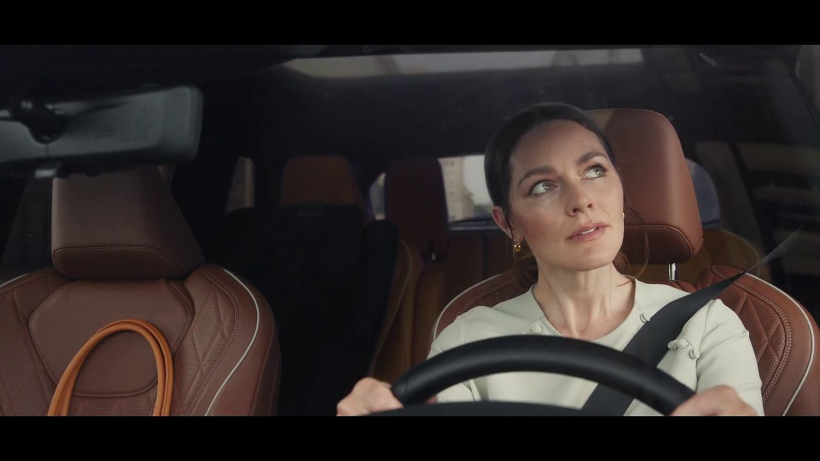 a woman driving a car with a steering wheel