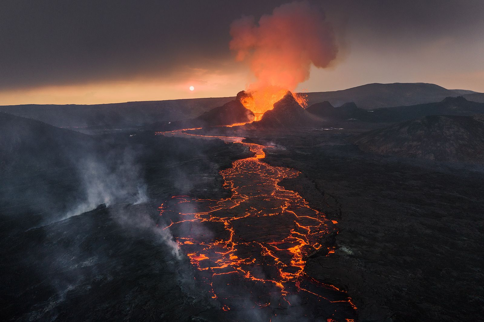 a large plume of smoke rising from a volcano