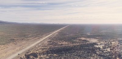 an aerial view of a road in the middle of the desert