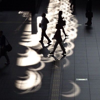 a group of people walking down a sidewalk