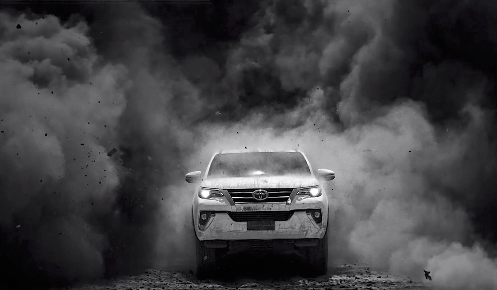 a white suv driving through a cloud of smoke