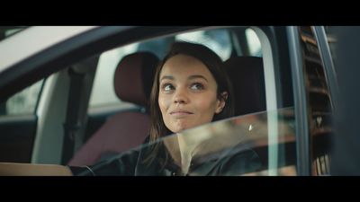 a woman sitting in a car looking out the window