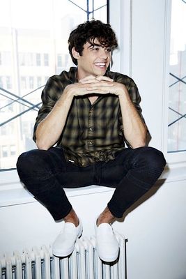 a man sitting on top of a radiator next to a window