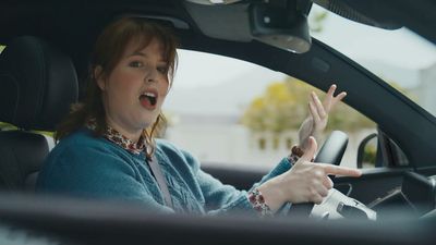 a woman driving a car with a surprised look on her face