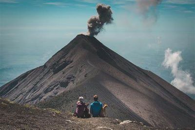 a couple of people sitting on top of a mountain