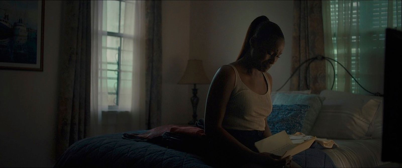 a woman sitting on a bed reading a book