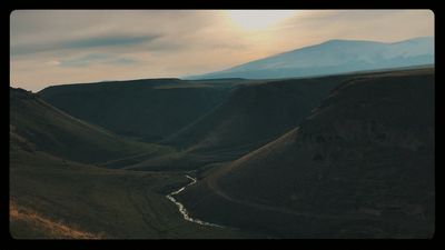 a river running through a valley surrounded by mountains