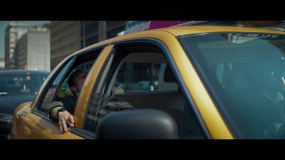 a man driving a taxi down a busy street