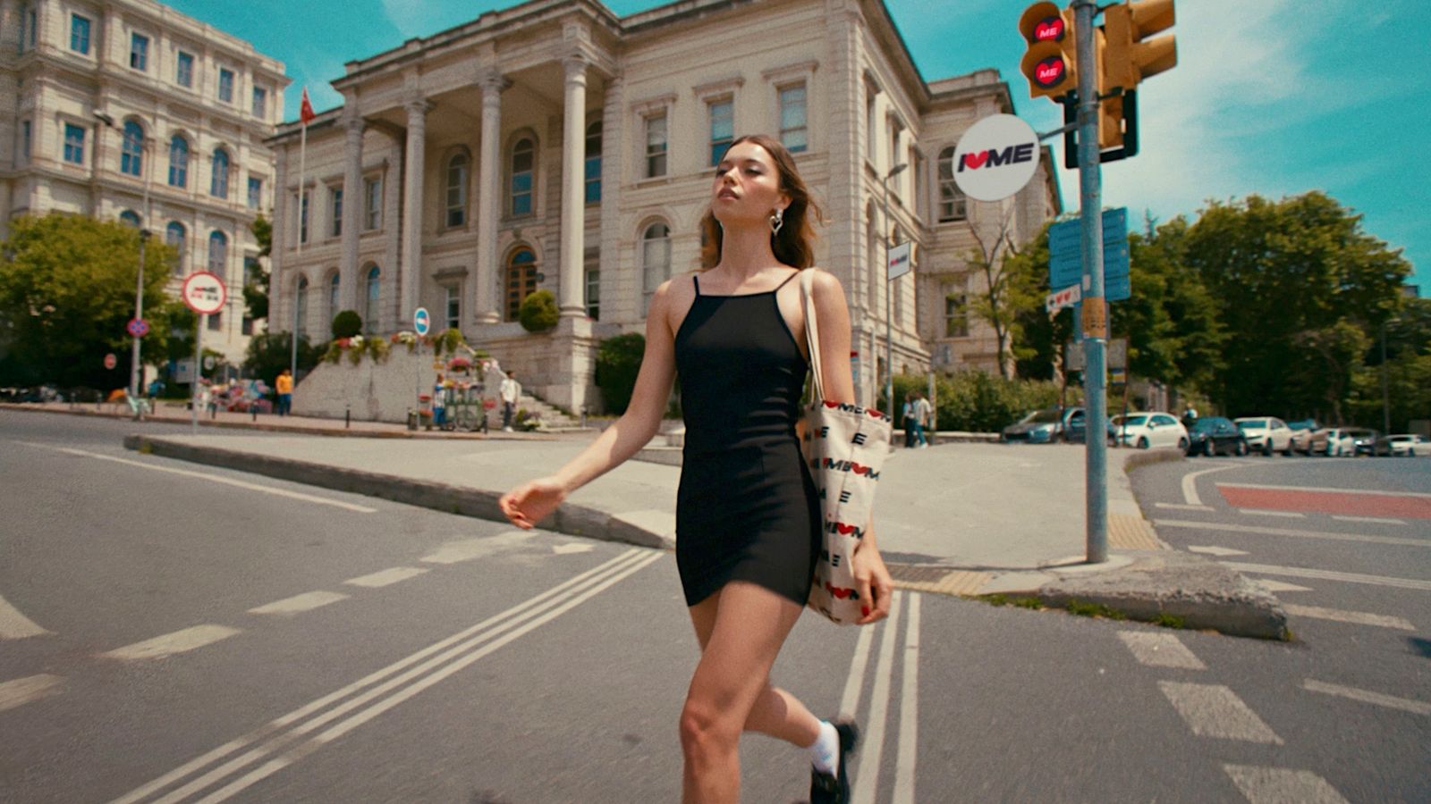 a woman crossing the street in front of a large building