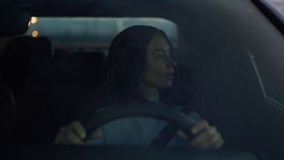 a woman driving a car in the dark