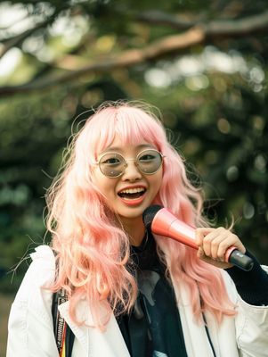 a woman with pink hair and glasses holding a baseball bat