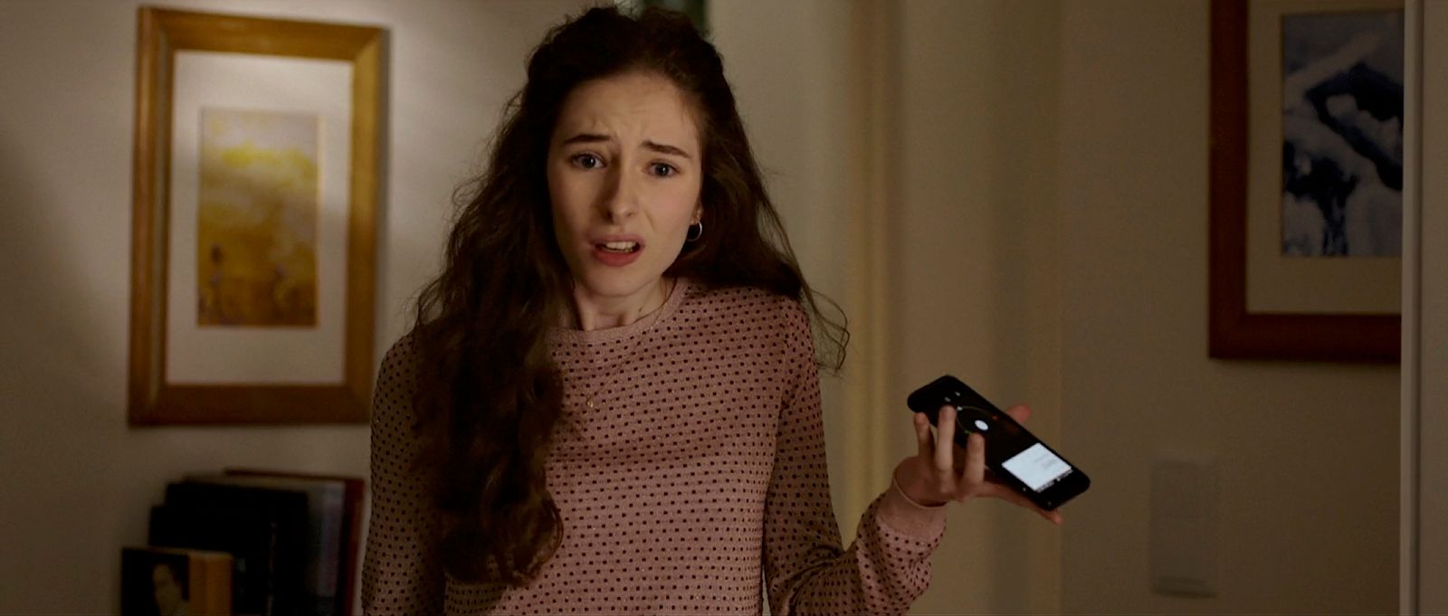 a woman holding a cell phone in her hand