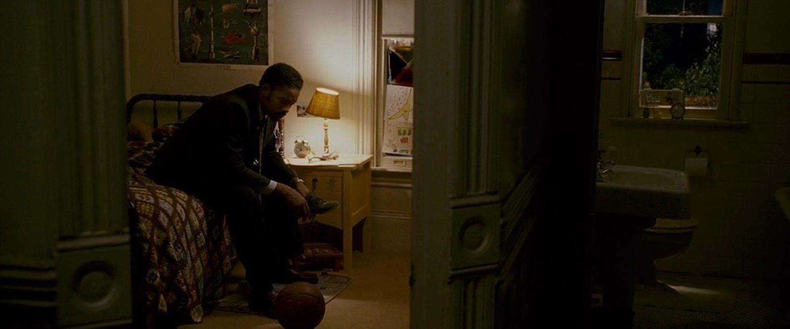 a man sitting on a bed in a dimly lit room