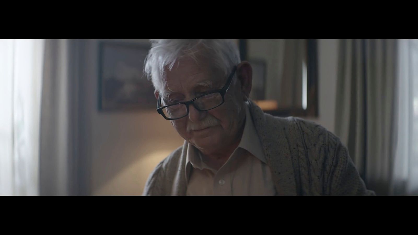 an older man wearing glasses looking at his cell phone