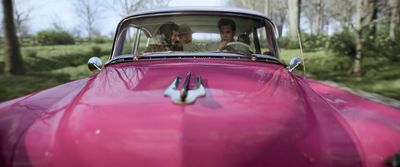 a man and a woman in a pink car