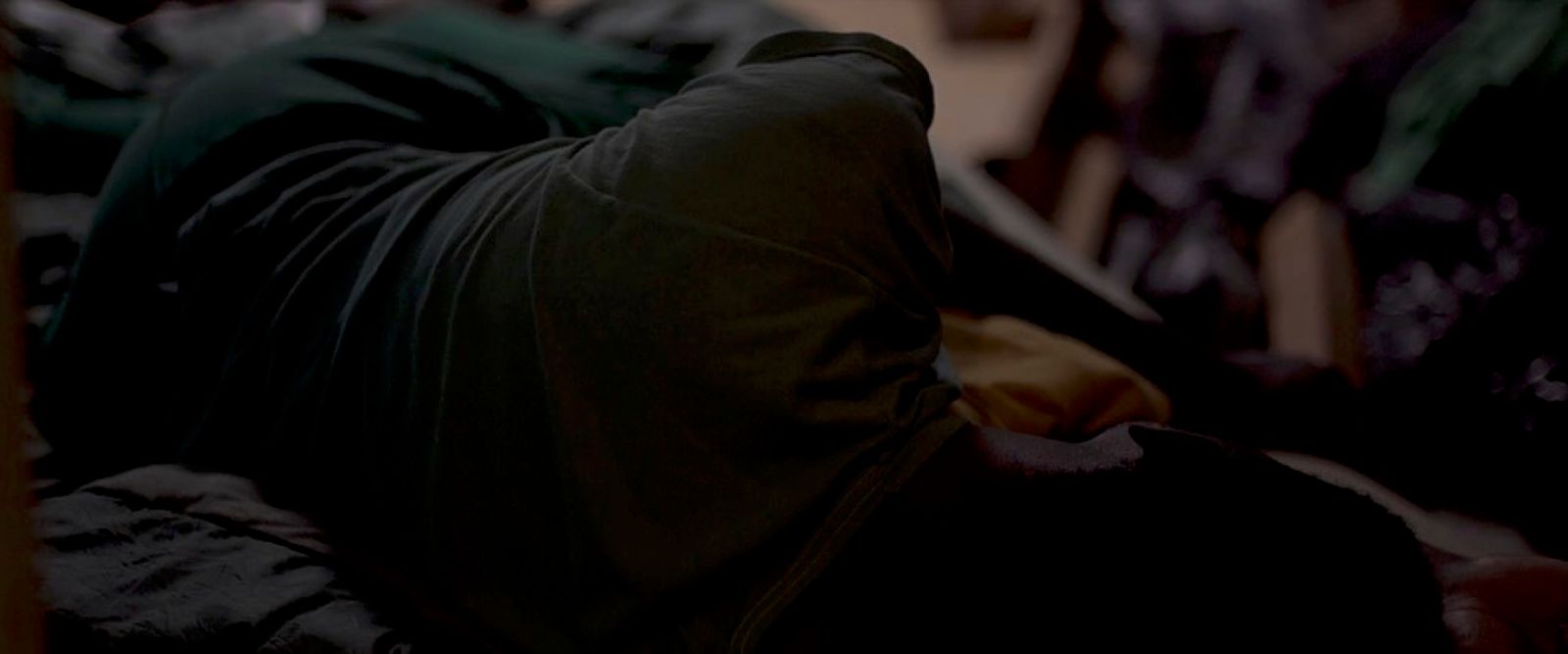 a person laying on a bed in a dark room