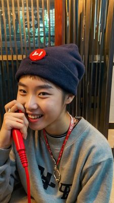 a woman sitting at a table with a red phone