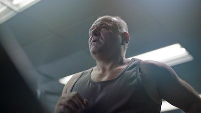 a man standing in front of a mirror in a gym