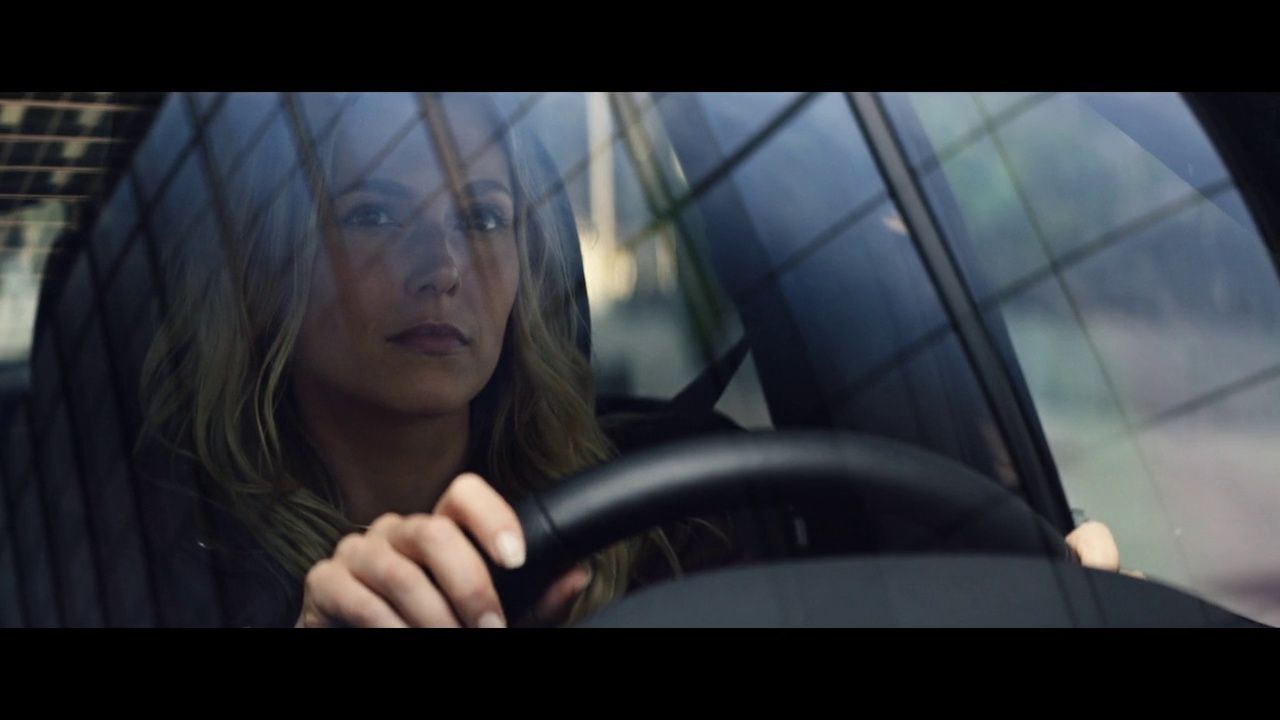 a woman driving a car with a steering wheel