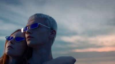 a man and a woman wearing sunglasses looking at the sky