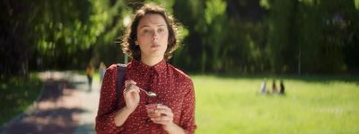 a woman in a red shirt holding a spoon in her hand