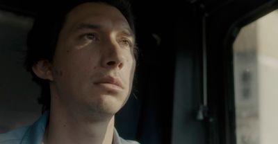 a man sitting in a car looking out the window