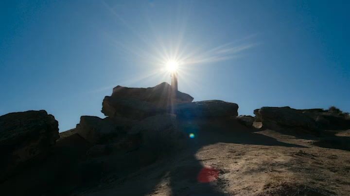 the sun shines brightly over a rocky outcropping