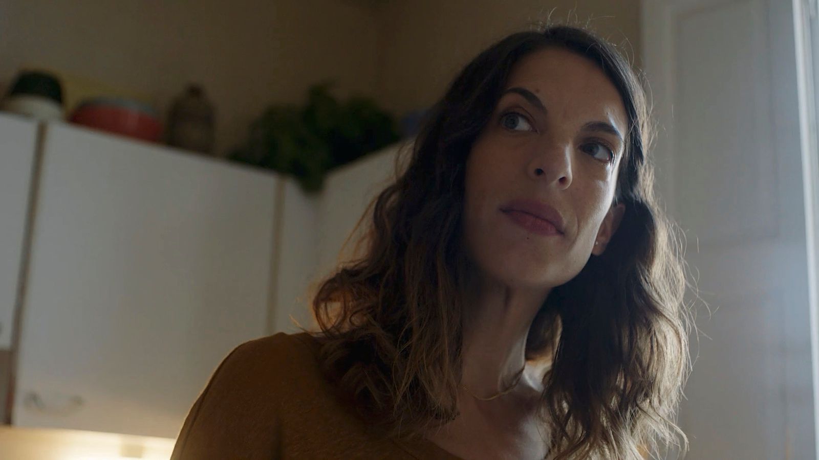 a woman standing in a kitchen looking up